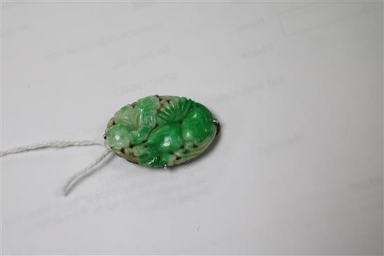 A 19ct century carved jadeite plaque, in later Chinese white metal brooch mount, 36mm.